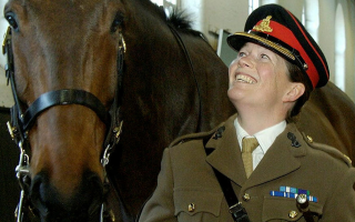 Major Erica Bridge looks up at a horse