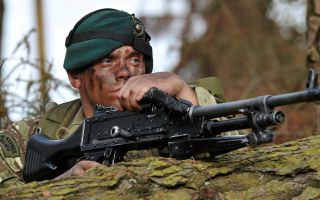 A Royal Marine Commando trains in woodland in Devon 