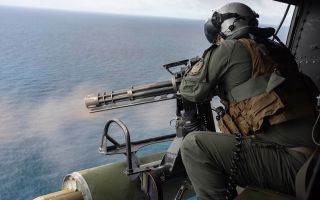 A US Marine Corps gunner fires an M134 minigun from a UH-1Y Venom helicopter, a role first carried out in Vietnam