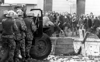 Soldiers shelter from an angry crowd behind the door of their Humber Pig armoured truck