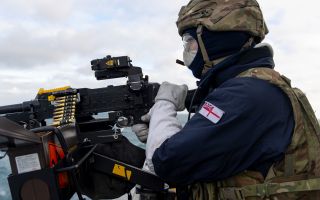 A member of HMS Duncan's upper deck weapons crew loads his GPMG with blank ammunition to practise counter-drone fire