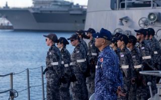 Sailors from the Royal Australian Navy and Japan Maritime Self-Defence Force fall in on the forecastle of HMAS Ballarat