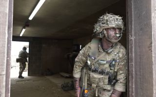 Soldier from the Royal Gibaltar Regiment takes up arcs on a doorway