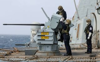 Personnel wearing protective clothing operate one of the 30mm Small Calibre Guns during live firing gunnery serials on board HMS Dragon - the crew also tested the Phalanx close-in weapon systems (Picture: MOD)