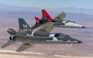 A T-7A Red Hawk (with red tail) and BTX-1 prototype fly together over Edwards Air Force Base - but the T-7 could end up flying over RAF Valley too