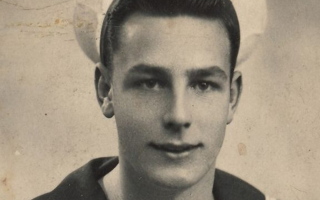 Black and white photograph of young D-Day Veteran John Dennet in sailor's uniform