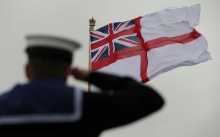 A sailor salutes as the White Ensign is raised on board the Royal Navy's flagship, HMS Prince of Wales (Picture: MOD)
