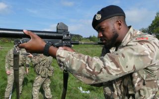 Soldiers from the Royal Bermuda Regiment get hands-on with the L104 baton gun, which fires a plastic round (Picture: BFBS)
