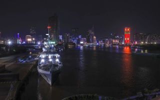 HMS Spey lit up at Saigon Port with the skyline of Ho Chi Minh City in the background pic MOD