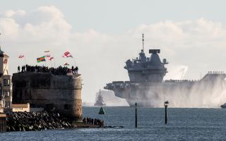 Crowds wave from the Round Tower as HMS Prince of Wales sails towards Portsmouth Naval Base