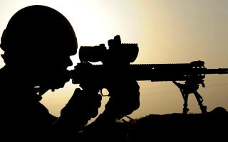 Anonymous soldier from 1st Battalion The Scots Guards looking through the scope of his sharpshooter rifle