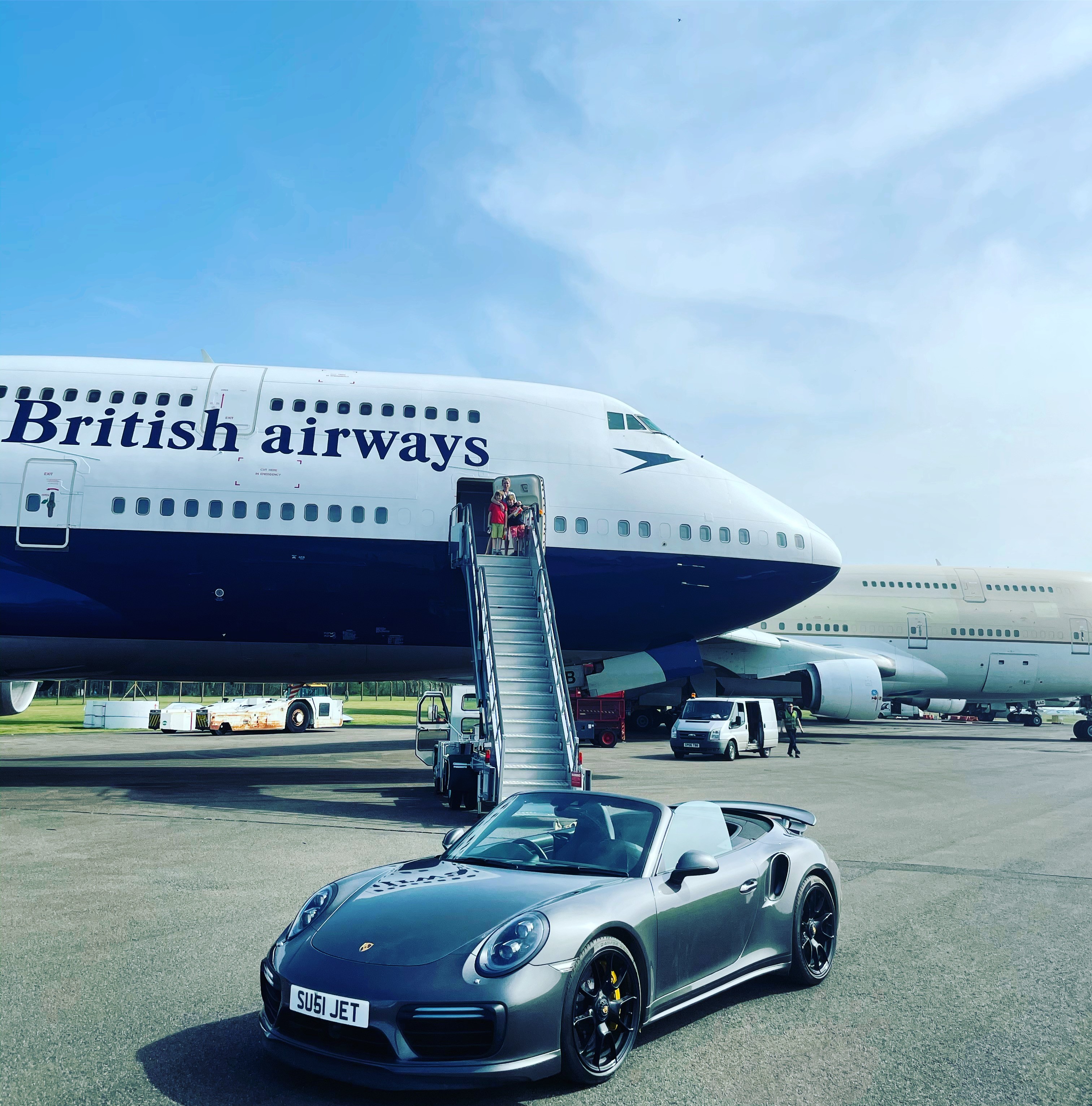 Suzannah Harvey with her children, her 747 and one of her Porsche sports cars. Credit: Suzannah Harvey
