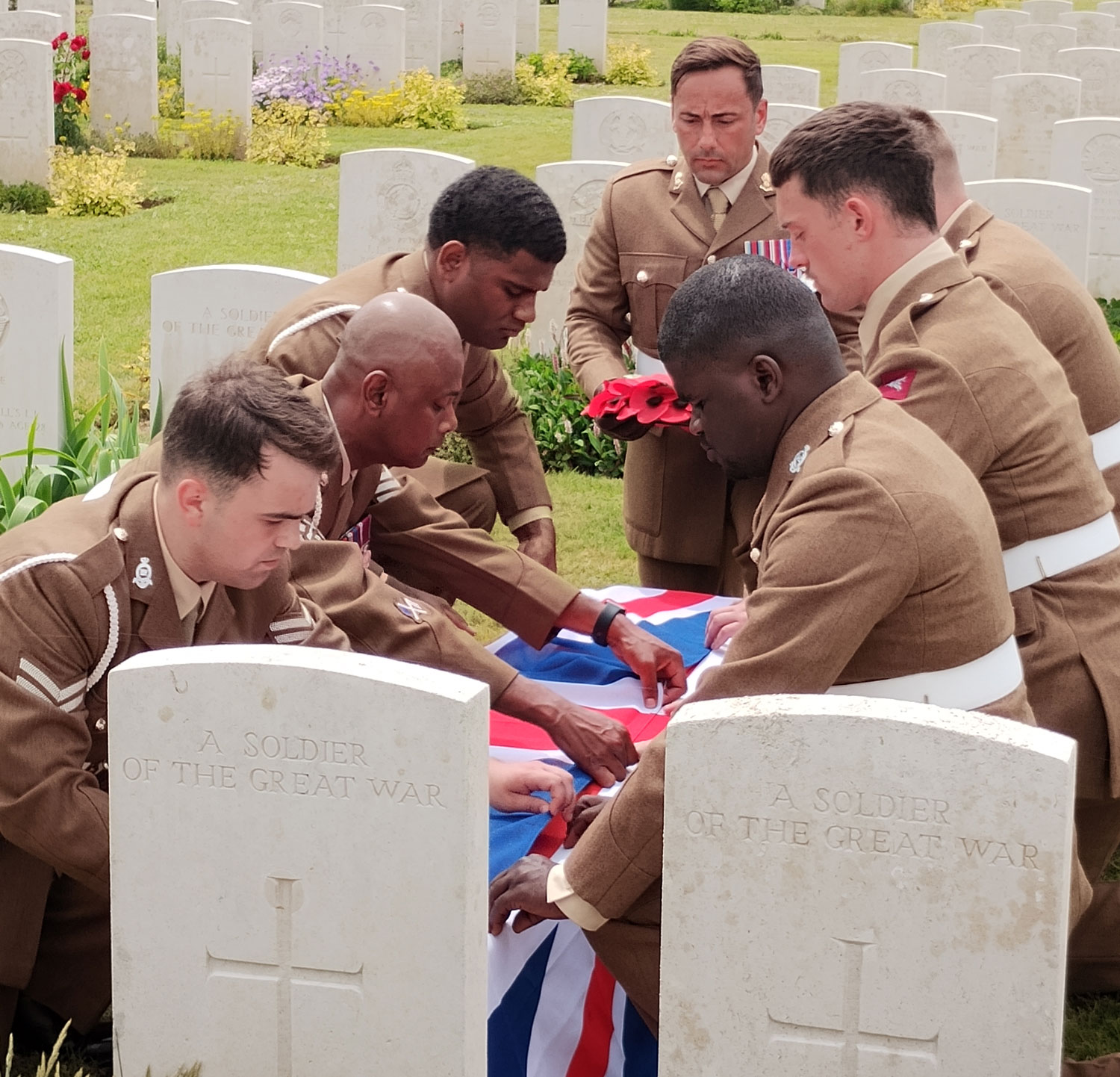 The bearer party from 14th Regiment Royal Artillery fold the Union Flag which covered the coffin CREDIT Crown Copyright