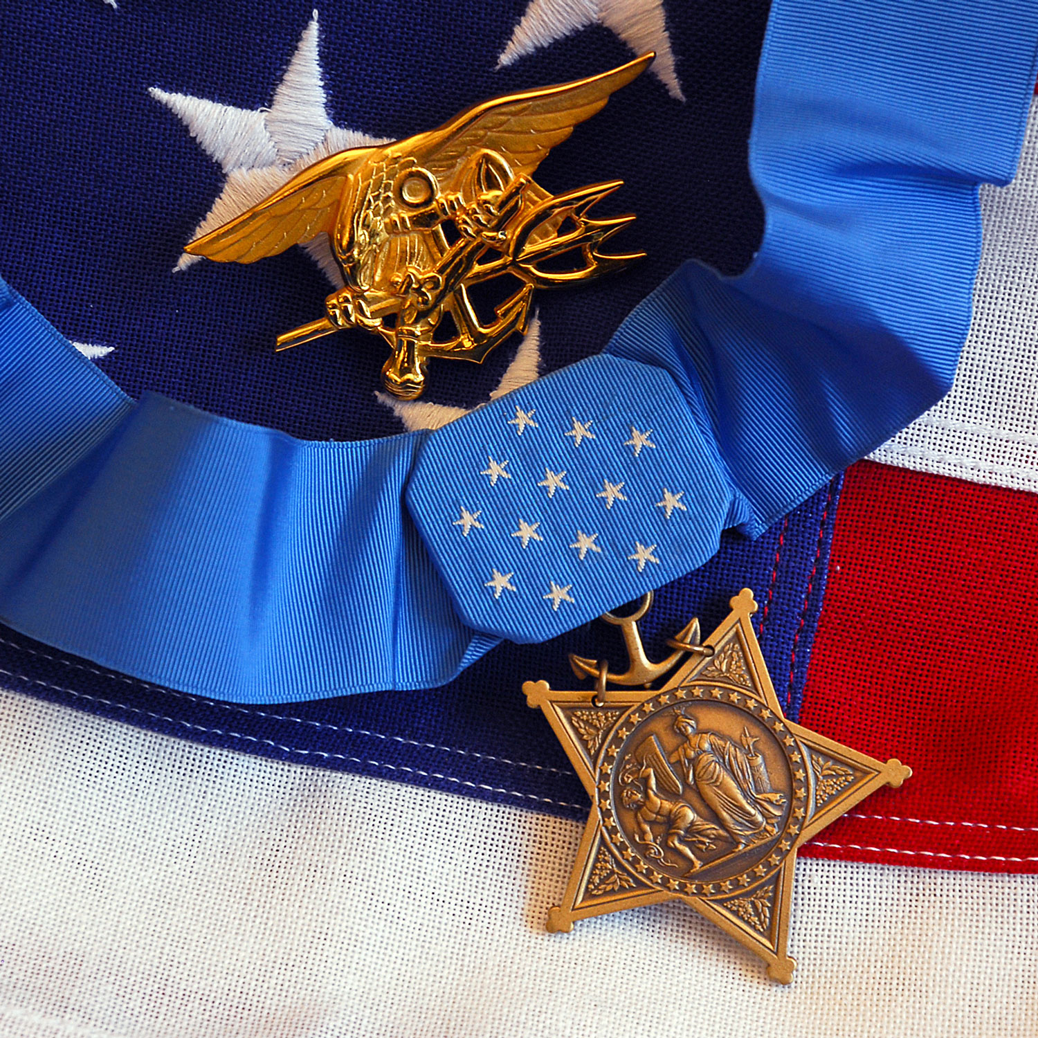 The Medal of Honor rests on a flag beside a SEAL trident during preparations for an award ceremony for Lt. Michael P. Murphy CREDIT US Department of Defense